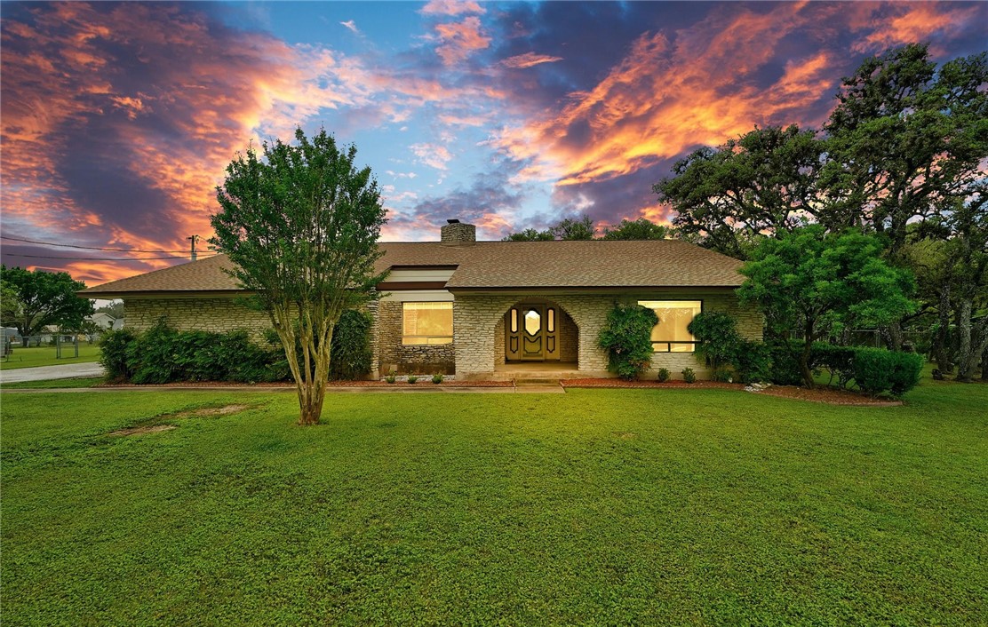 a view of a house with a yard and tree s