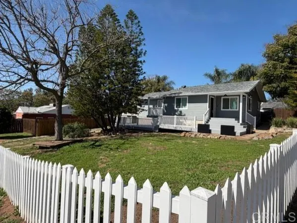 a front view of a house with a garden and plants