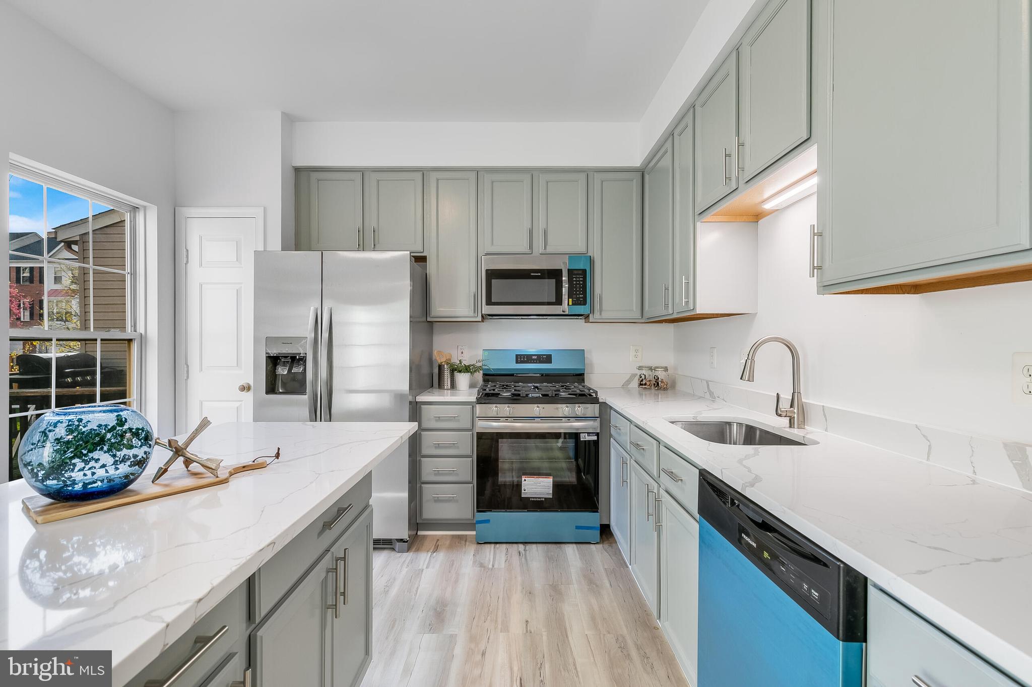 46716 Cavendish Square Sterling, VA 20165 - Photo 9 of 42 a kitchen with stainless steel appliances granite countertop a sink stove refrigerator and cabinets