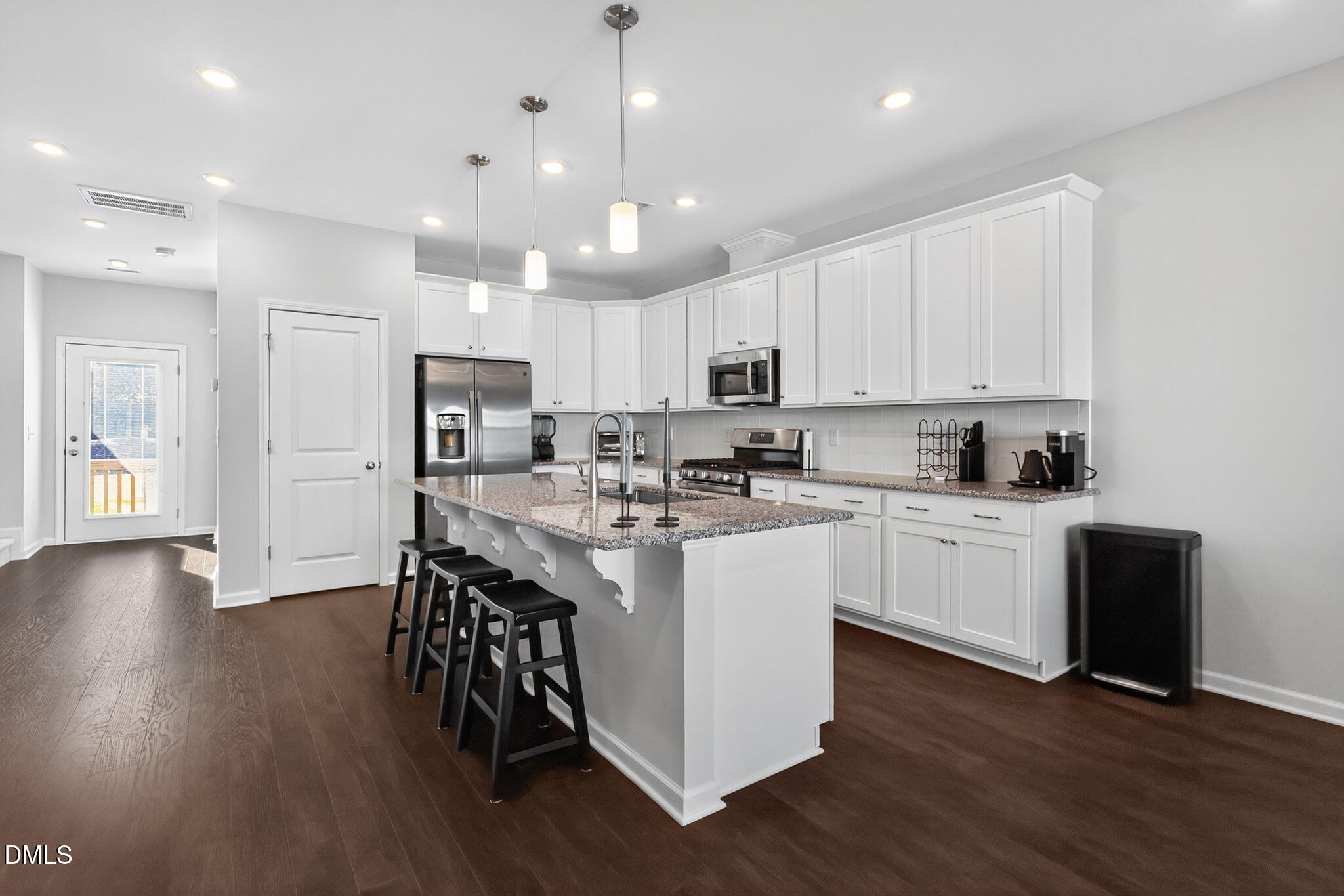 1118 Commack Drive Durham, NC 27703 - Photo 6 of 30 a kitchen with stainless steel appliances granite countertop a white cabinets and wooden floor