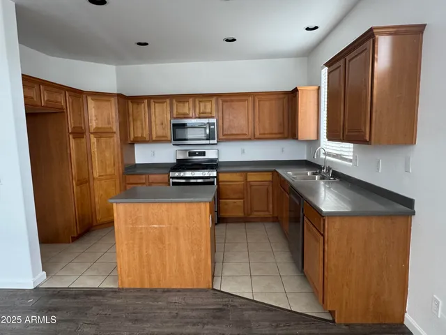 a kitchen with stainless steel appliances granite countertop a stove a sink dishwasher and a refrigerator