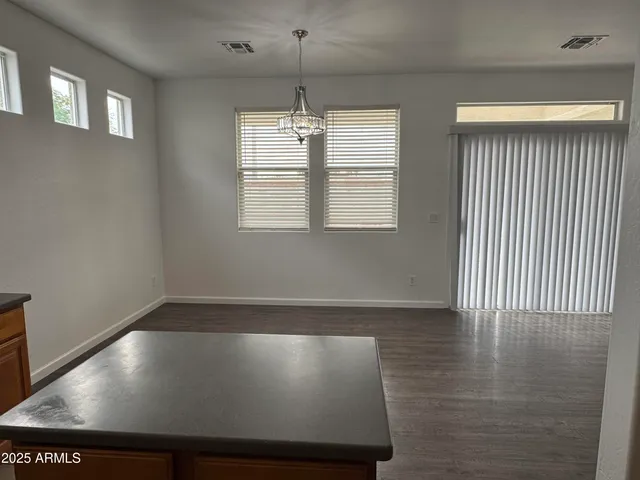 an empty room with wooden floor fireplace and windows