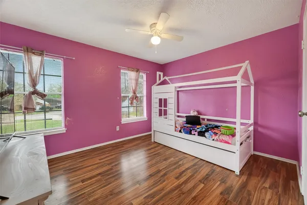 a bedroom with a bed and wooden floor