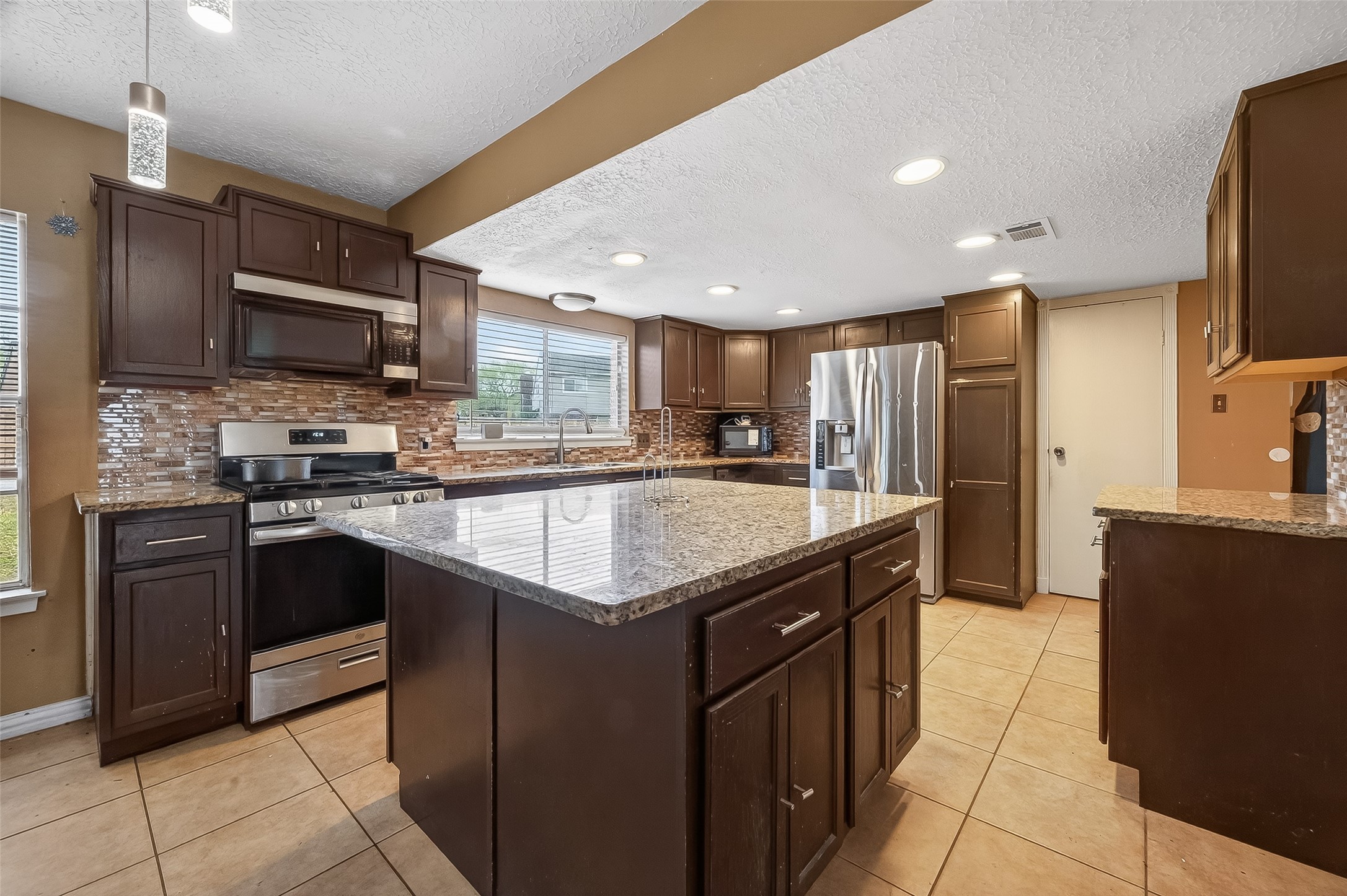 16006 El Toro Court Webster, TX 77598 - Photo 8 of 19 a kitchen with stainless steel appliances granite countertop a stove a sink dishwasher a refrigerator and a microwave oven