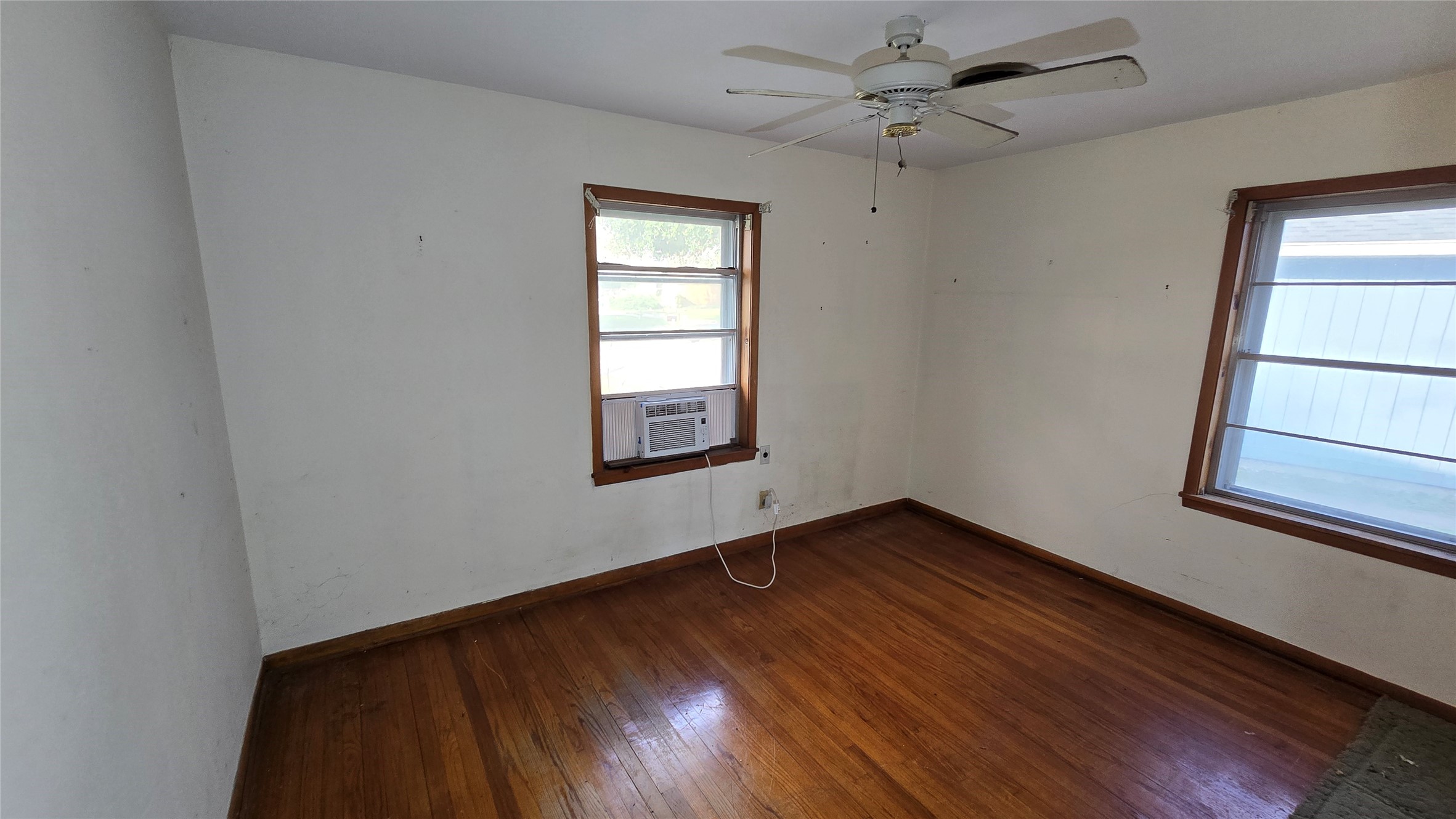 103 Long Drive Baytown, TX 77521 - Photo 16 of 21 an empty room with wooden floor chandelier fan and windows