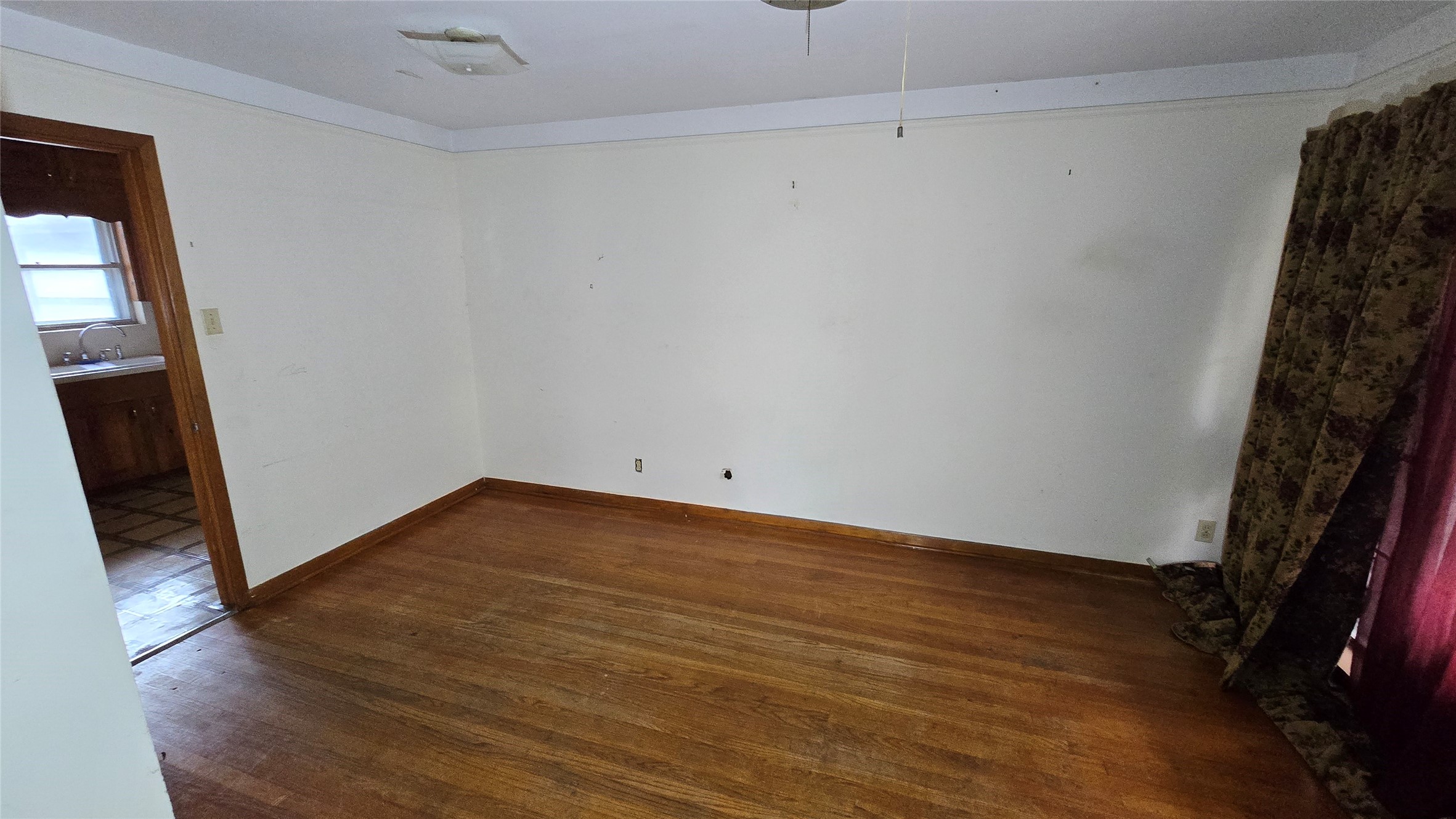 103 Long Drive Baytown, TX 77521 - Photo 8 of 21 a view of an empty room with wooden floor and a window