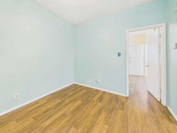 a view of an empty room with wooden floor