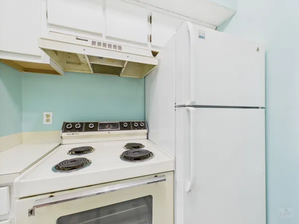 a kitchen with a refrigerator and white stove