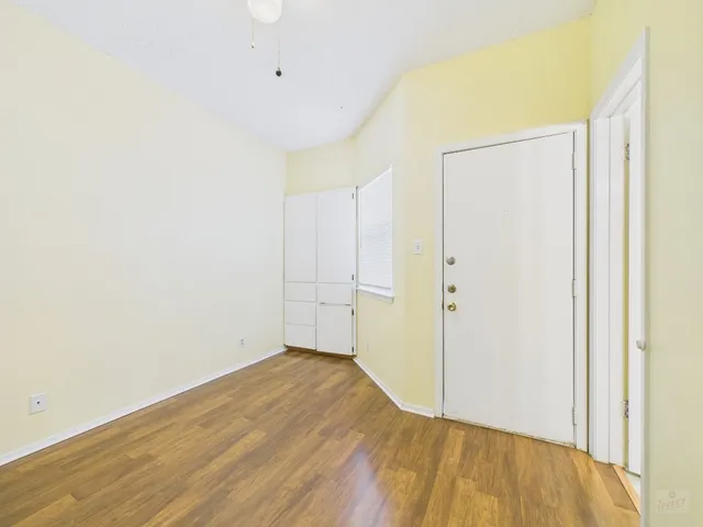 a view of empty room with wooden floor