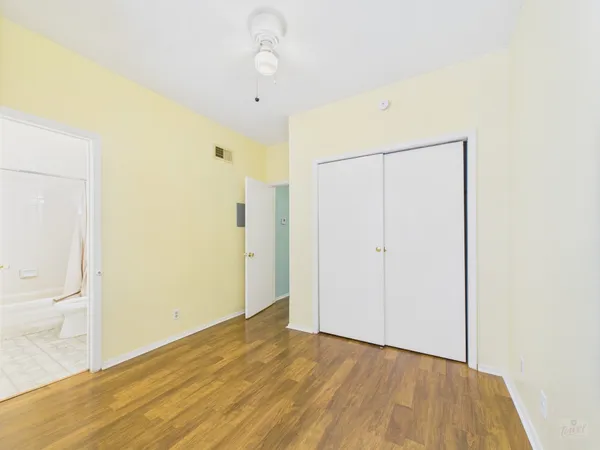a view of an empty room with wooden floor