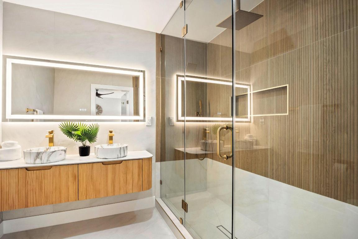 7010 Meadow Run Austin, TX 78745 - Photo 14 of 26 Full bathroom with double vanity and a shower stall