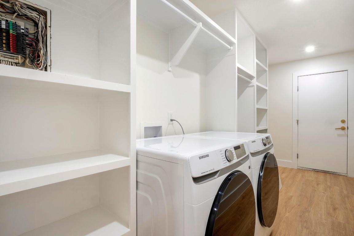 7010 Meadow Run Austin, TX 78745 - Photo 18 of 26 Laundry room featuring light wood finished floors, electric panel, independent washer and dryer, and recessed lighting