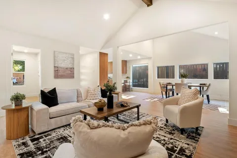 a living room with furniture wooden floor and a view of kitchen