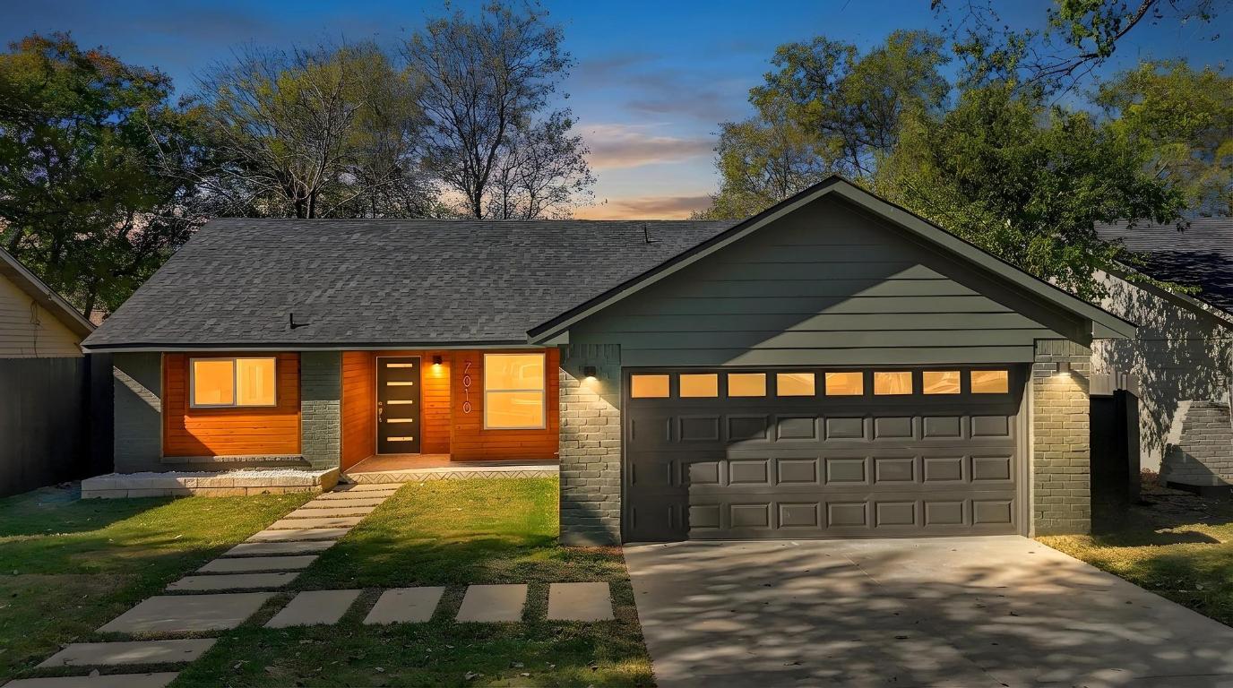 7010 Meadow Run Austin, TX 78745 - Photo 21 of 26 View of front of home with concrete driveway, a front lawn, and an attached garage