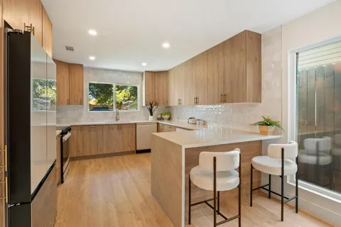 a kitchen with kitchen island granite countertop wooden cabinets and white appliances