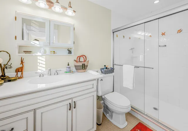 a bathroom with a sink a toilet a mirror and shower