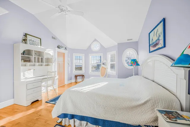 a bedroom with a bed and a large window with wooden floor
