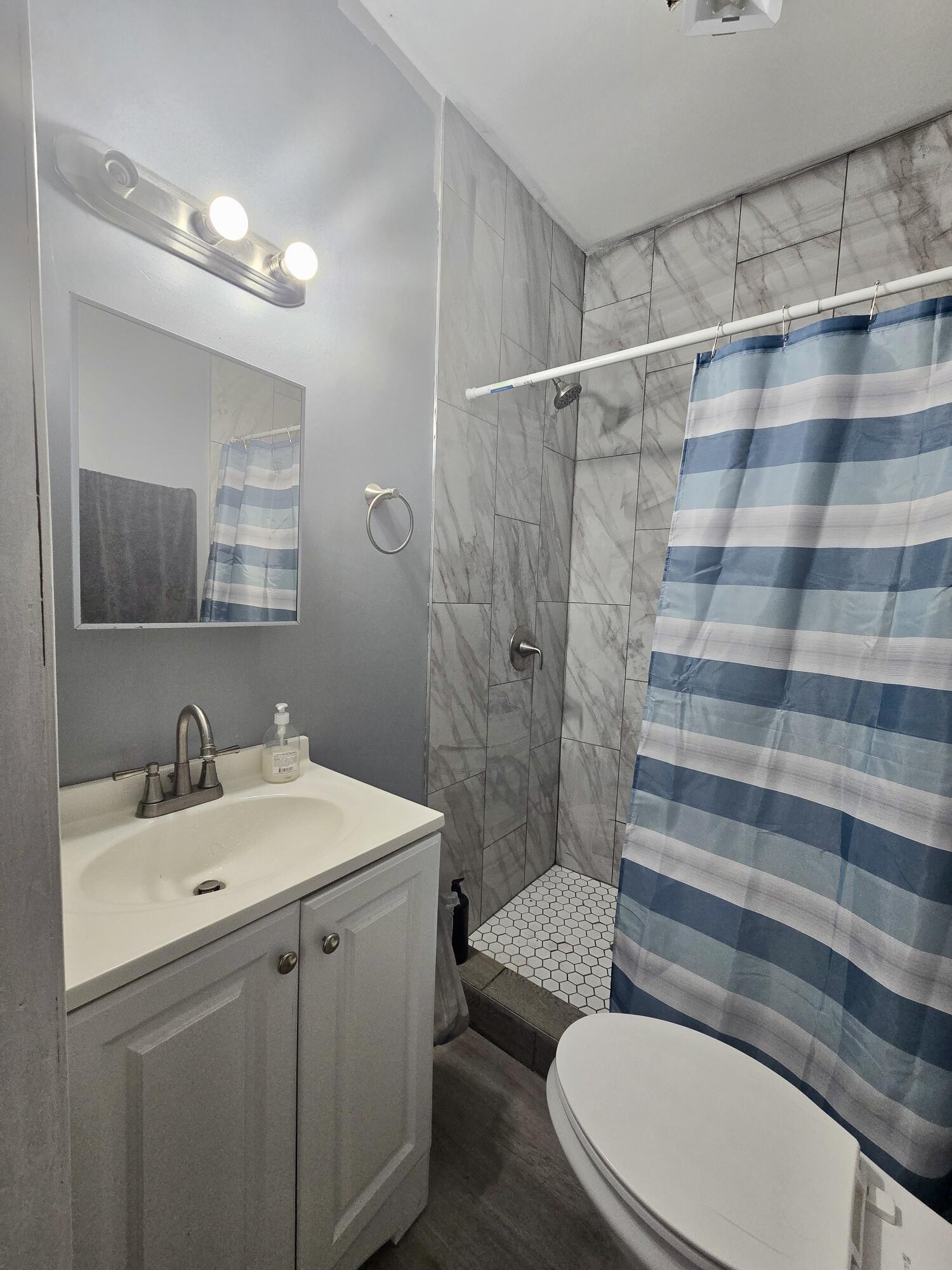4613 Maryland Street Gary, IN 46409 - Photo 17 of 24 a bathroom with a sink toilet mirror and shower