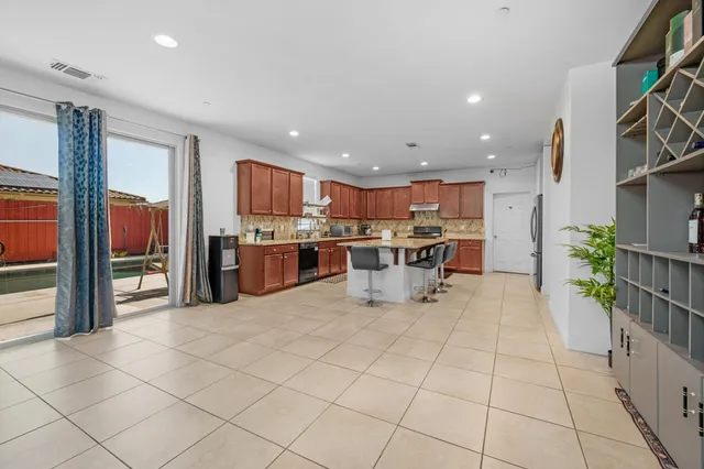 a kitchen with stainless steel appliances granite countertop a stove a sink a microwave and a refrigerator