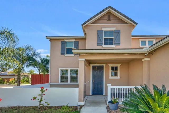 a view of a white house with a swimming pool and wooden fence