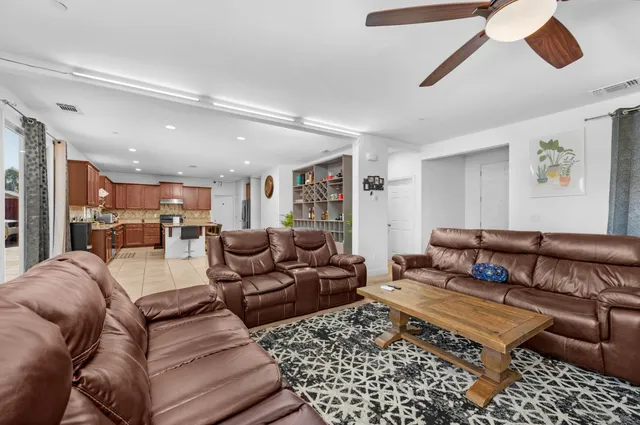a living room with furniture ceiling fan and a rug
