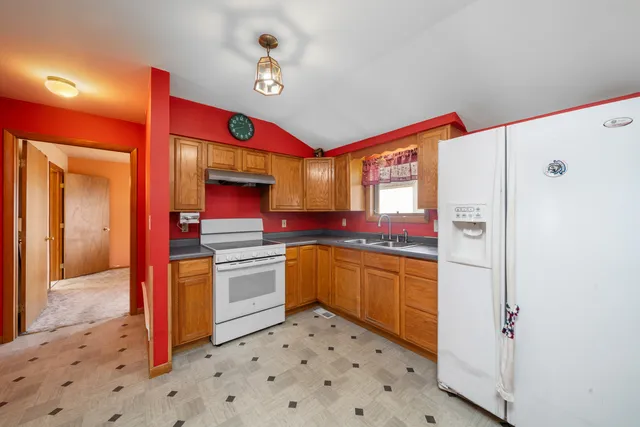 a kitchen with stainless steel appliances granite countertop a refrigerator and a stove