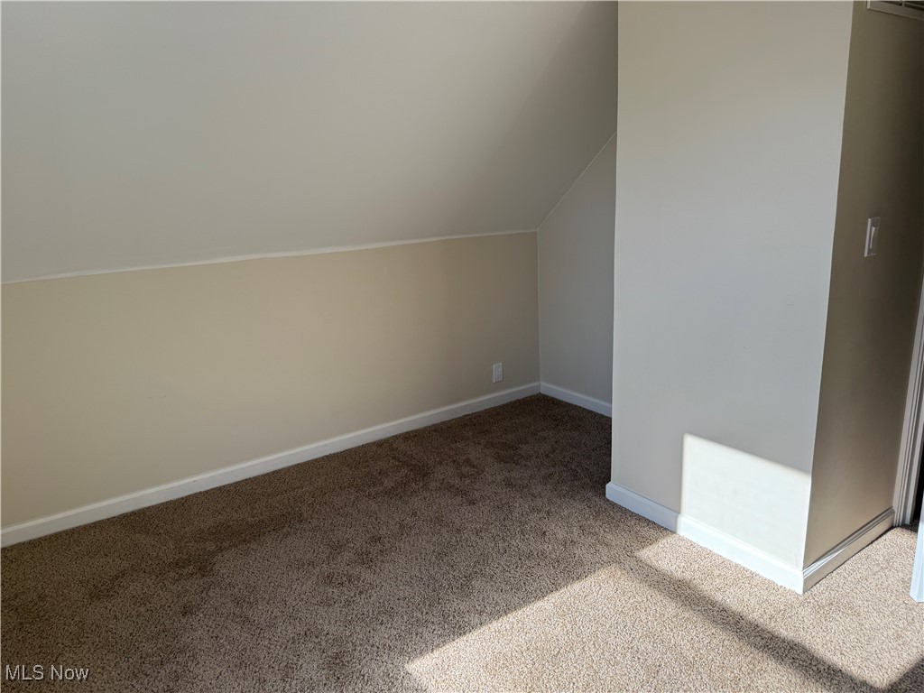 1877 Clyde Road Madison, OH 44057 - Photo 10 of 19 Additional living space with carpet and vaulted ceiling