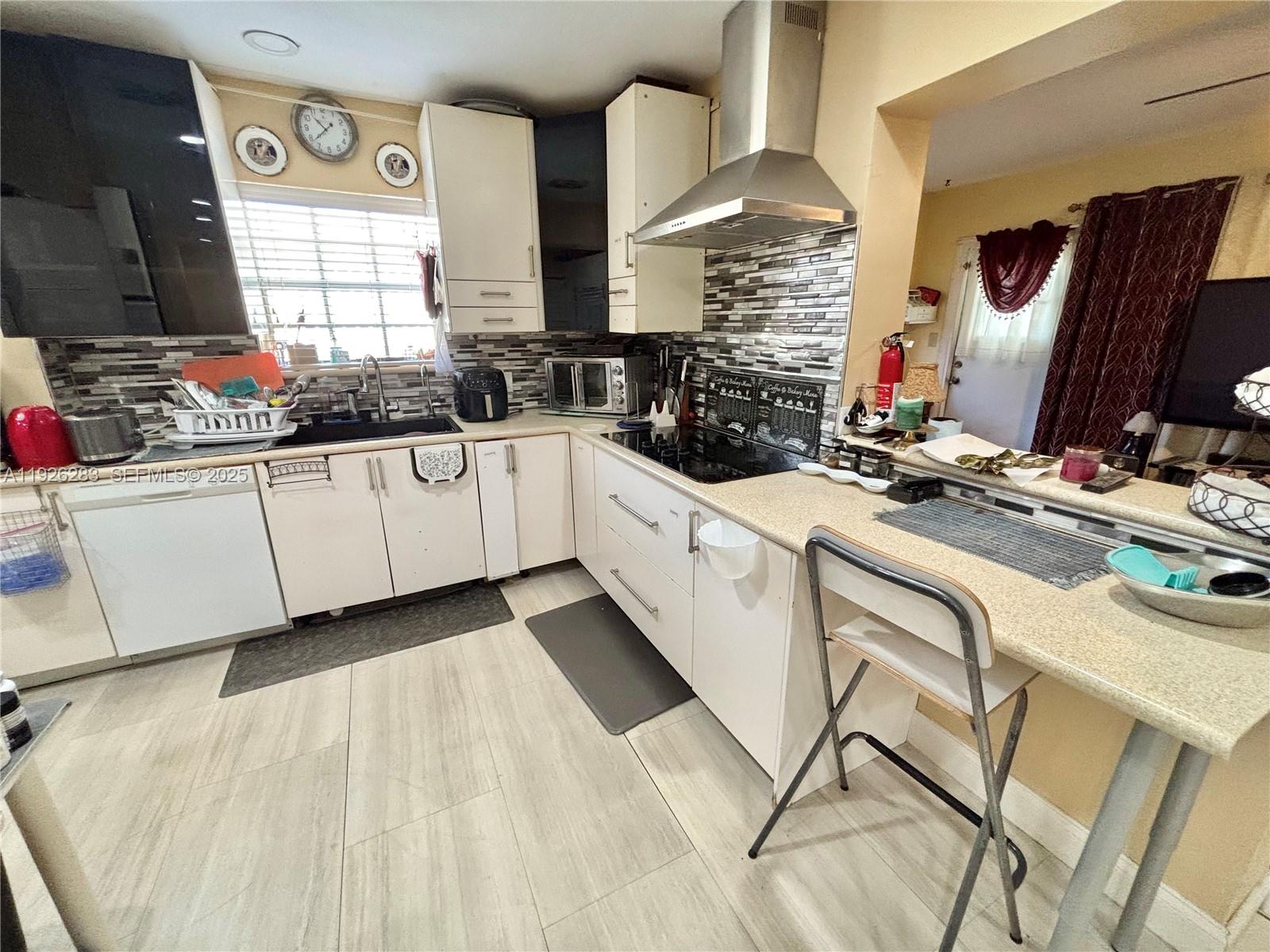 7331 Normandy Street Miramar, FL 33023 - Photo 11 of 29 a kitchen with a sink stove and cabinets