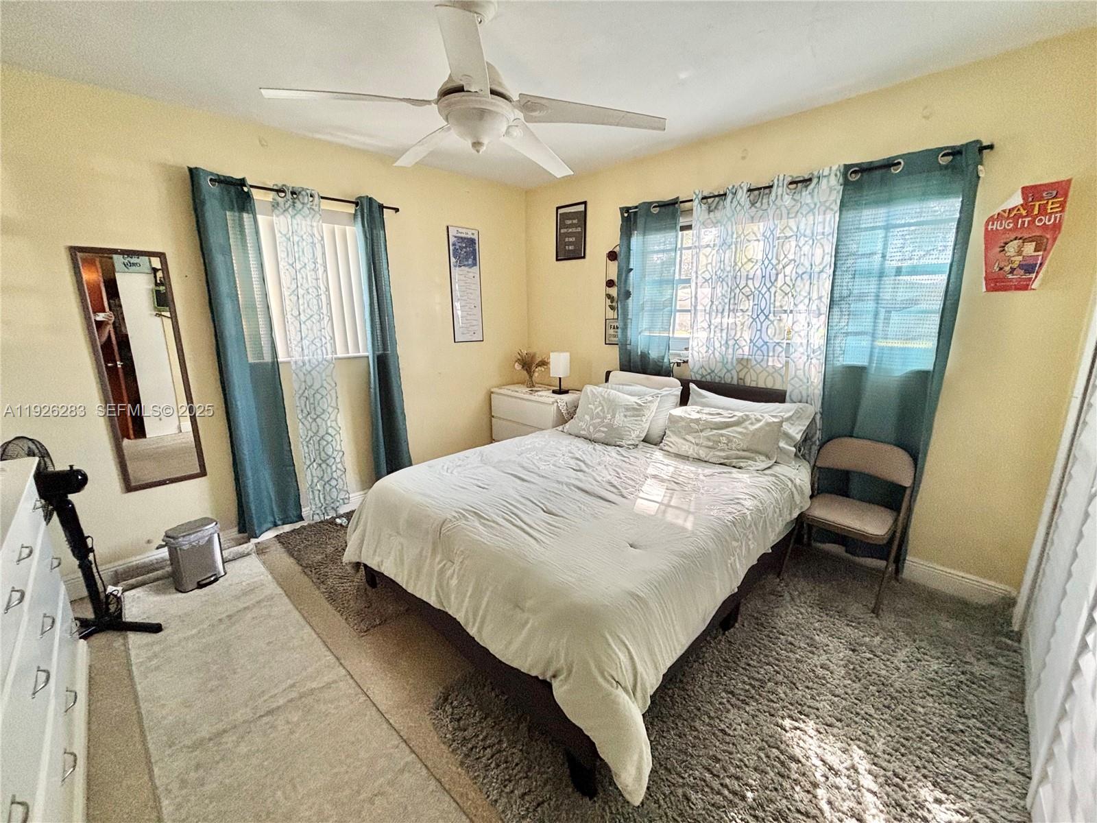 7331 Normandy Street Miramar, FL 33023 - Photo 16 of 29 a bedroom with a bed a mirror on the dresser and a dresser