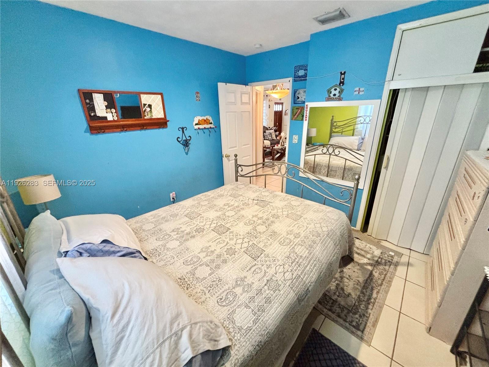 7331 Normandy Street Miramar, FL 33023 - Photo 19 of 29 a bedroom with a bed and a refrigerator