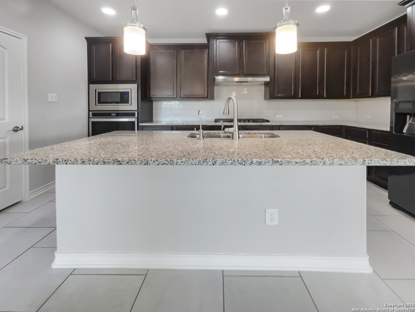 23006 Woodlawn Ridge San Antonio, TX 78259 - Photo 13 of 20 a kitchen with kitchen island granite countertop a sink a counter top cabinets and stainless steel appliances