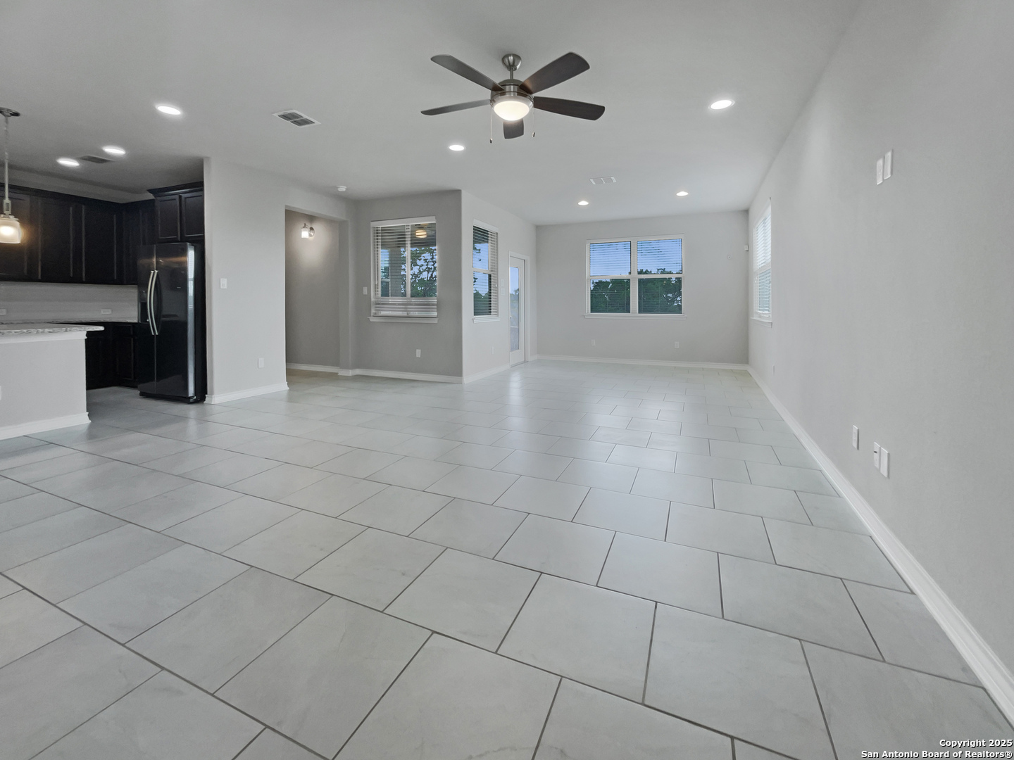 23006 Woodlawn Ridge San Antonio, TX 78259 - Photo 3 of 20 wooden floor in an empty room with a kitchen
