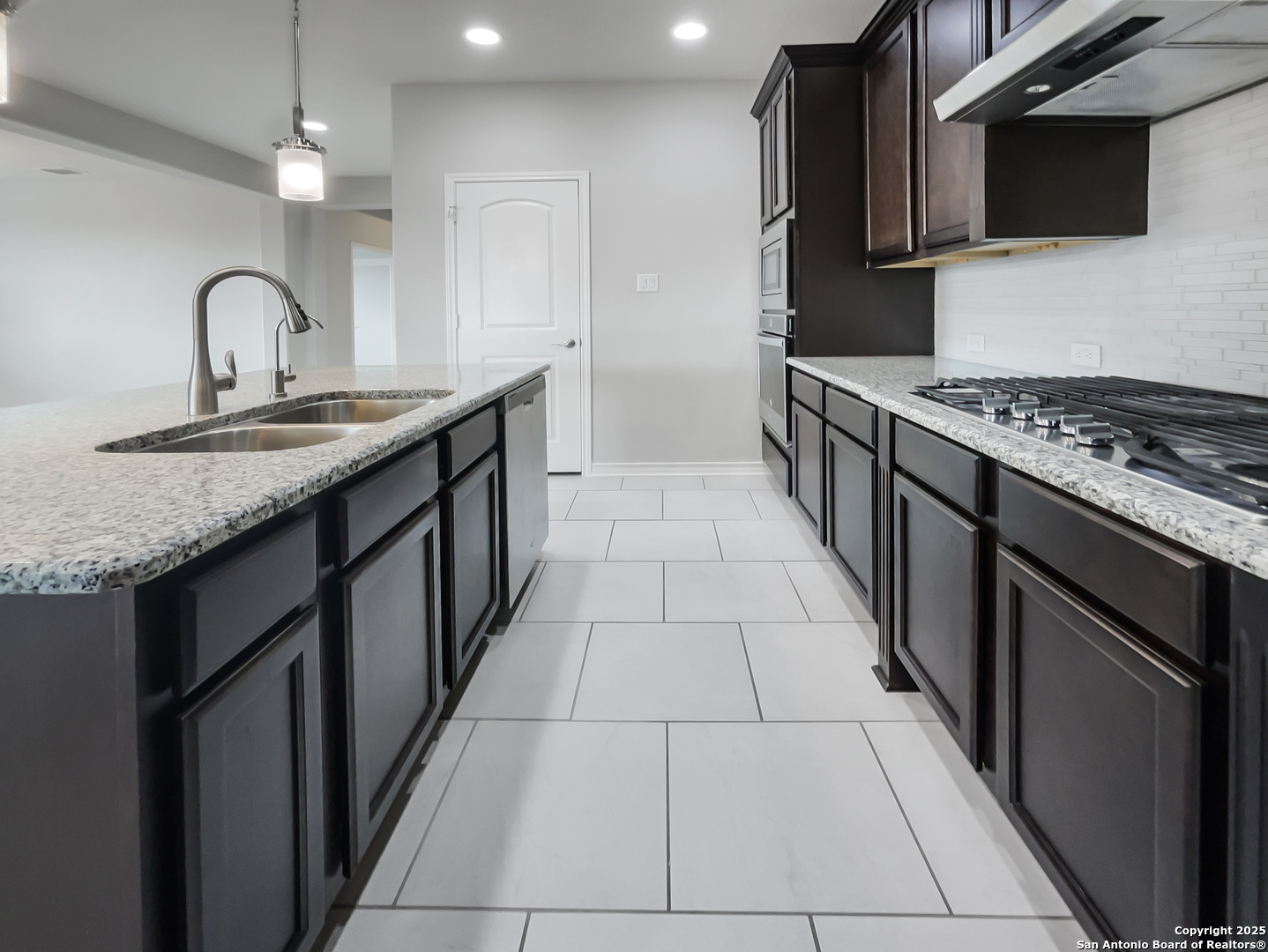 23006 Woodlawn Ridge San Antonio, TX 78259 - Photo 6 of 20 a kitchen with stainless steel appliances a sink stove top oven and cabinets