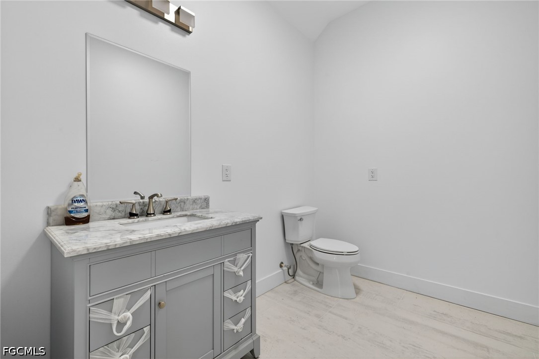 2665 Oil Well Road Naples, FL 34120 - Photo 32 of 40 a bathroom with a granite countertop toilet and a sink
