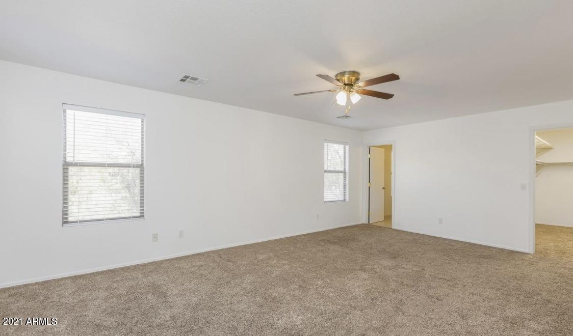 9446 Virginia Avenue Phoenix, AZ 85037 - Photo 11 of 19 an empty room with windows and chandelier fan