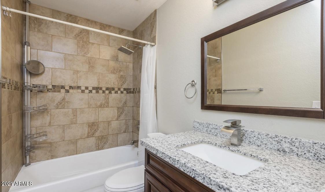 9446 Virginia Avenue Phoenix, AZ 85037 - Photo 14 of 19 a bathroom with a granite countertop sink toilet and shower