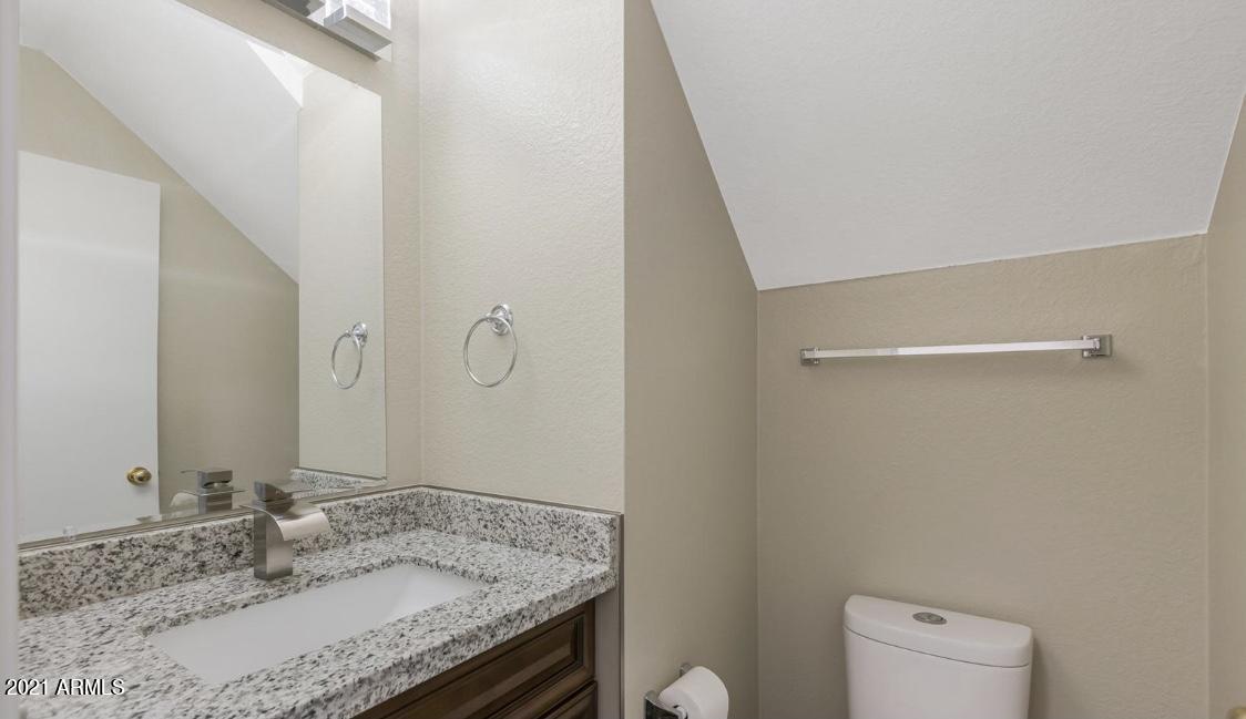 9446 Virginia Avenue Phoenix, AZ 85037 - Photo 16 of 19 a bathroom with a granite countertop sink and a mirror