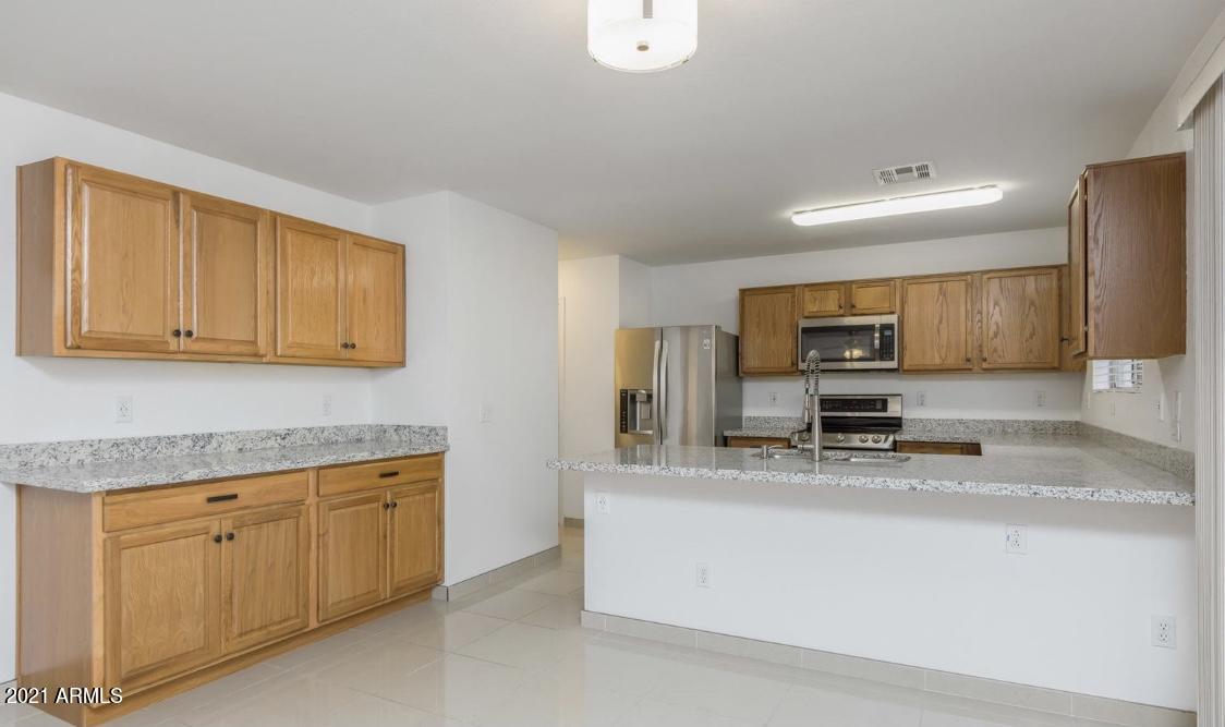 9446 Virginia Avenue Phoenix, AZ 85037 - Photo 5 of 19 a kitchen with a sink a stove and cabinets