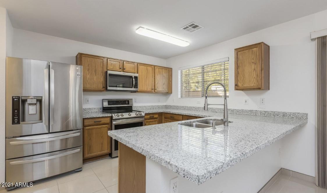 9446 Virginia Avenue Phoenix, AZ 85037 - Photo 6 of 19 a kitchen with stainless steel appliances granite countertop a sink stove and refrigerator