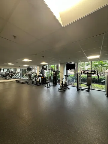 a view of a gym with pool table and chairs