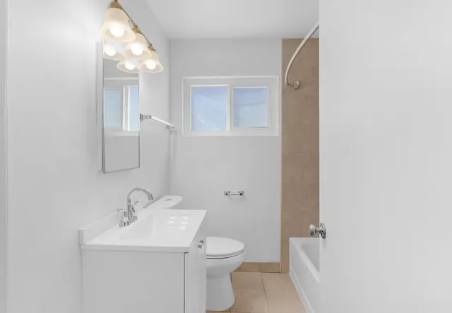 a bathroom with a toilet a sink and mirror