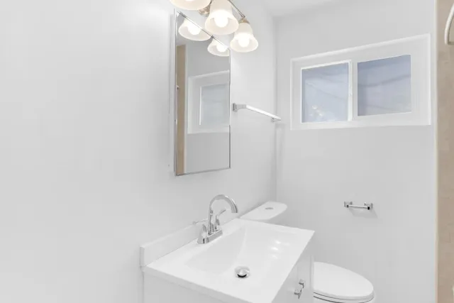 a bathroom with a toilet sink and mirror