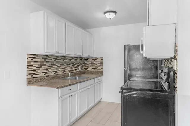 a kitchen with granite countertop a refrigerator and a stove