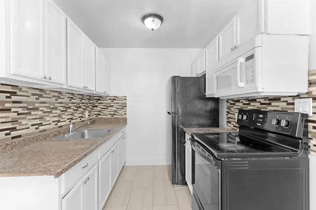 a kitchen with stainless steel appliances granite countertop a stove a refrigerator and a sink