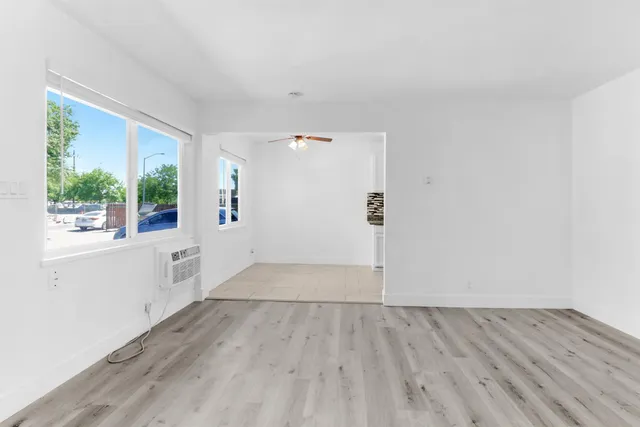 an empty room with windows and fan