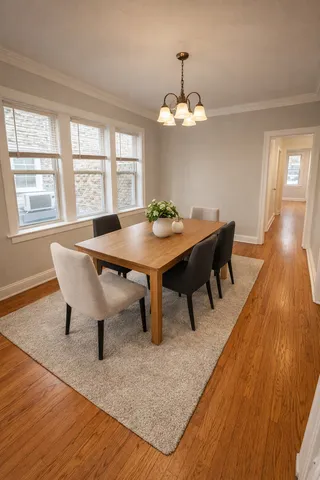 a view of a dining room with furniture a chandelier and wooden floor