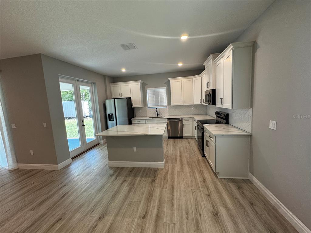 13101 Southwest 72nd Terrace Road Ocala, FL 34473 - Photo 3 of 18 a kitchen with a sink wooden floor and a refrigerator