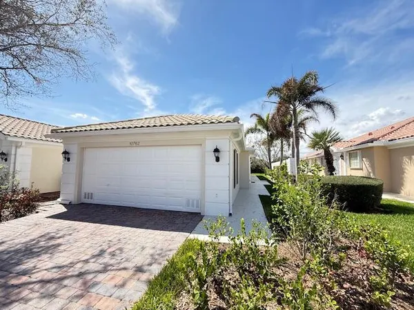 a view of a house with a yard and a garage