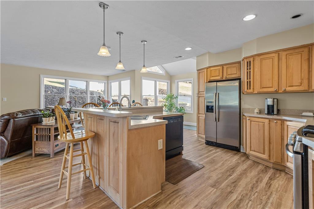 300 McCombs Road Venetia, PA 15367 - Photo 11 of 25 a kitchen with stainless steel appliances granite countertop a refrigerator a sink dishwasher a stove and a dining table with wooden floor