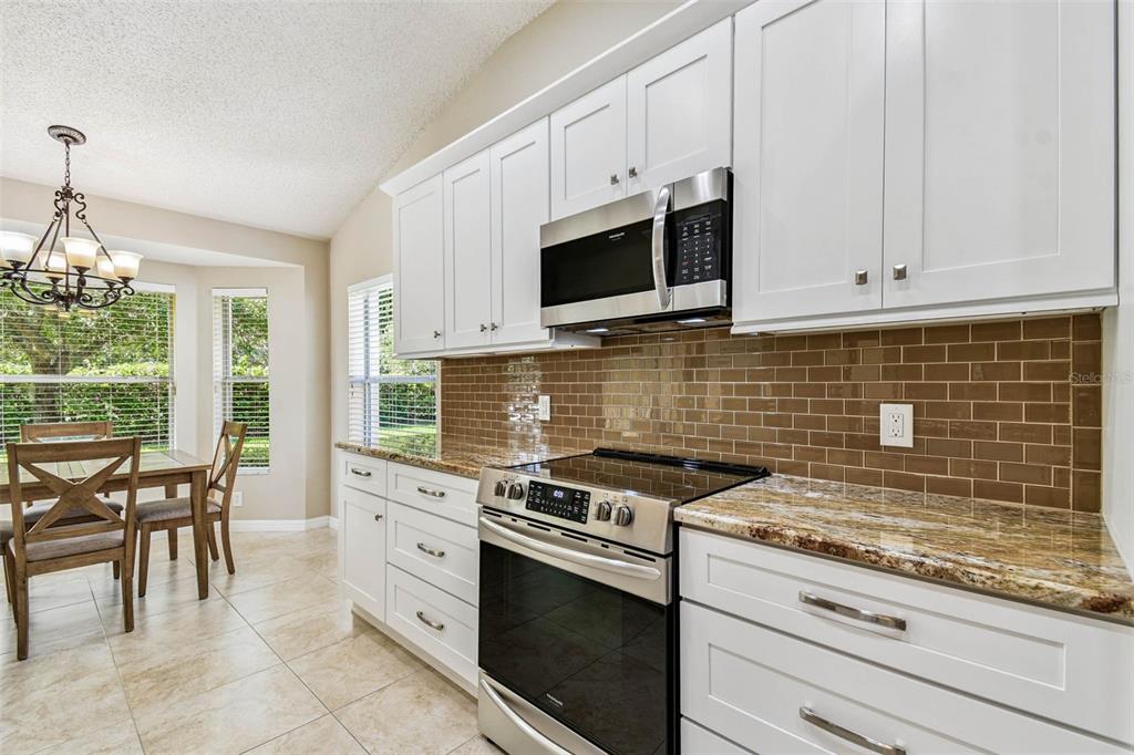 12202 Aaron Terrace Trinity, FL 34655 - Photo 16 of 41 a kitchen with white cabinets and appliances